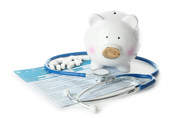 Poster - Ceramic piggy bank with pills, stethoscope and test results on white background