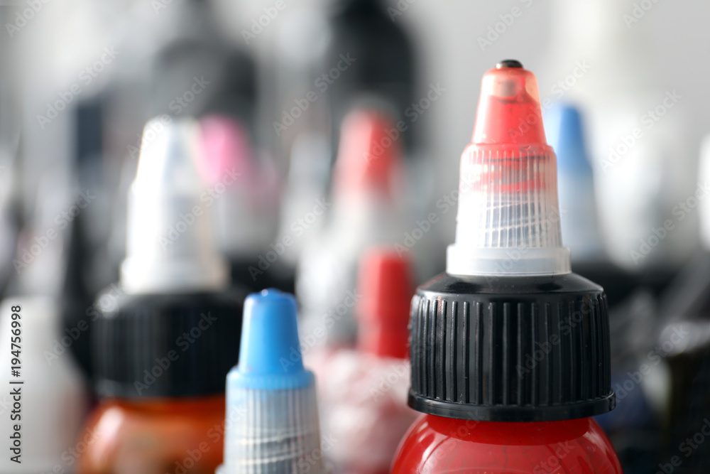 Many bottles with ink in tattoo salon, closeup