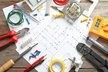 Wall Mural - Different electrical tools and circuit diagram on wooden background