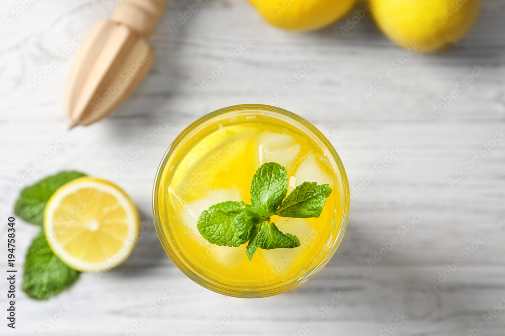 Glass of fresh lemonade on table