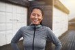 © Flamingo Images - Smiling young Asian woman standing outside before a run