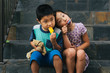 © Carrie Yuan - Boy and girl eating ice pops while sitting on stairs