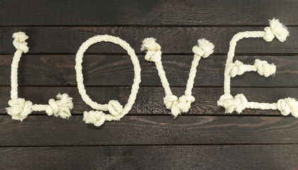 Love form with rope on wood background.