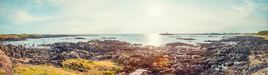 Wall Mural - Panoramic shot of seascape with vulcanic stones all around at Jeju Island - South Korea