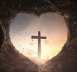 © Choat - Good Friday concept: Heart shape of empty tomb stone with the cross over meadow sunrise background
