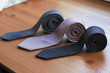 three men's tie rolled into a roll on a wooden background