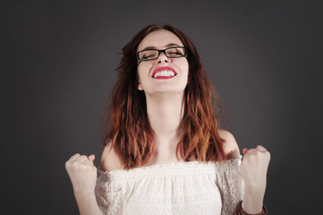 Young and funny hipster woman is feeling so proud. Studio shot with dark background.