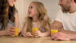 © motortion - Happy healthy family drinking orange juice with smiles on faces, morning at home