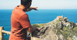 © A_B_C - Tourist traveler photographer enjoy pictures sea scape on photo camera on background ocean gaztelugatxe steps, hipster man looking on nature horizon, relax holiday, blank space blue waves view