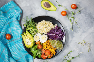 Wall Mural - Healthy vegan lunch bowl. Vegan buddha bowl. Vegetables and nuts in buddha bowl on concrete background. Top view.