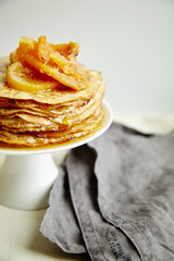 Wall Mural - Crepes cake with orange jam and honey on white cake stand. Pancake breakfast concept