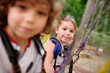 © Evgeniy Kalinovskiy - children - a boy and a girl in the rope park pass obstacles. Brother and sister climb the rope road