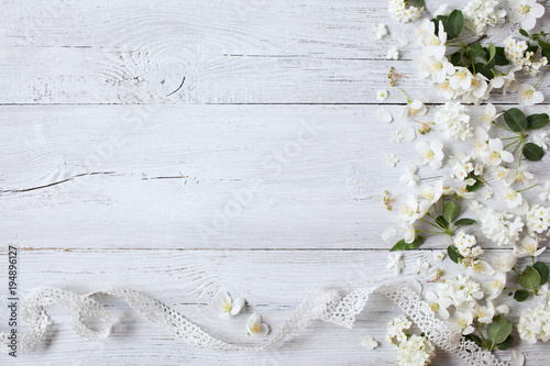 Dekoracja na wymiar  biale-tlo-drewniane-biale-wiosenne-kwiaty-i-koronkowa-wstazka