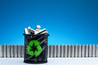Ecology recycling concept, nature energy, used or new battery on recycle garbage bin, rechargeable AA accumulator, alkaline batteries in row on blue background