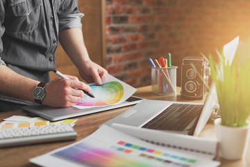 young creative artist of web design in hat with graphic tablet in modern loft office
