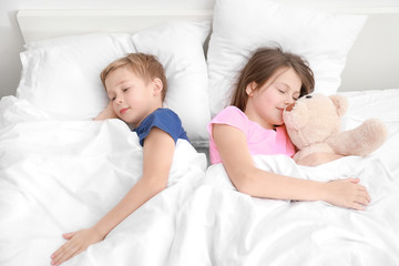 Wall Mural - Cute little brother and sister sleeping in bed at home