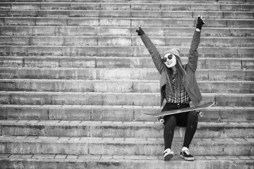 A young hipster girl is riding a skateboard. Girls girlfriends f