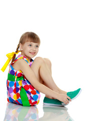 a little girl in a dress with a pattern from multi-colored circl