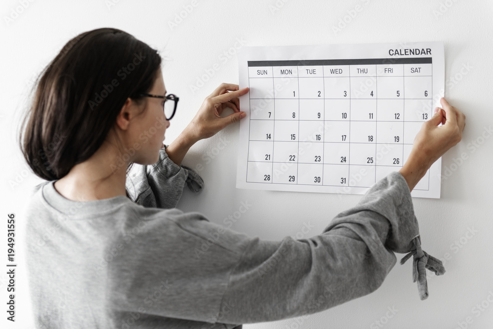 Woman checking the calendar Stock Photo | Adobe Stock