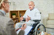Portrait of disabled senior man in wheelchair sharing problems with psychiatrist during therapy session, copy space