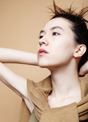 Headshot Portrait of  girl wearing casual clothes. Beige backgro