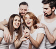 © Raisa Kanareva - Portrait of happy girls and guys singing in microphone over white background.