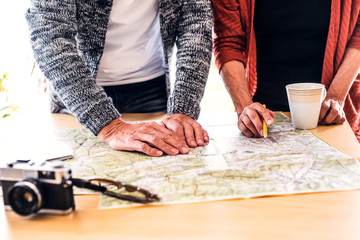 Canvas Print - Senior couple with map at home, making plans.