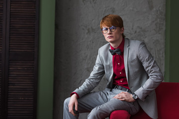 Male fashion model in eyeglasses dressed in grey suit