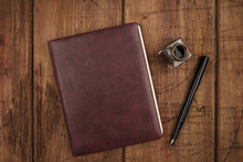 A Leather Bound Journal, And Ink Well And Pen