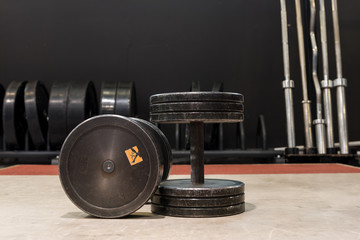 Two old and used gym black metal dumbbells. Gym and fitness equipment.