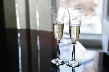 two wedding decorated transparent glasses with champagne