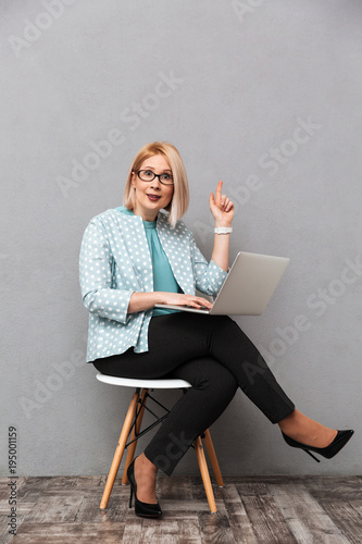 Shocked business woman using laptop computer pointing have an idea Poster