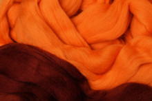 Bright Colored Merino Wool For Felting And Needlework, Hobby. The Stripes Of Burgundy Color And Orange Yarn Folded Into Abstract Pattern. Abstract Art Background