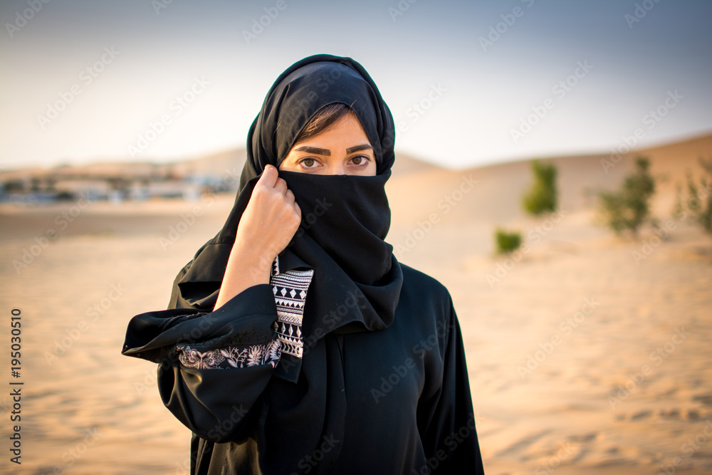 Portrait of beautiful Muslim woman wearing traditional Arabian clothing in  the desert. Stock Photo | Adobe Stock