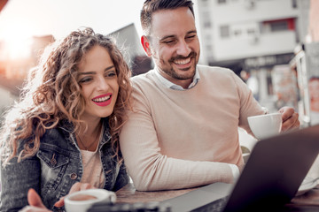 Sticker - Happy couple at coffee shop looking at laptop.