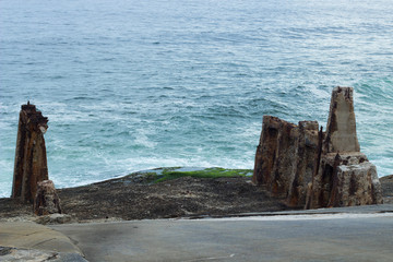 ruins on the edge of the sea with waves crashing on the coast scene and natural real