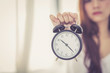 © N_studio - Beautiful asian young woman wake up in morning annoyed alarm clock holding hand, girl hurry wake late with appointment, lifestyle concept.