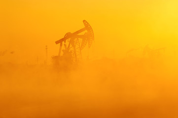 Wall Mural - The oil sucking machines in the vapour lakeside sunrise.