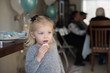 © David Prahl - little girl holding a cupcake with icing on face at family birthday party