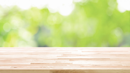 Wood table top on blur abstract natural green bokeh background