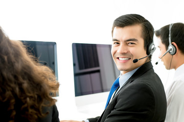 Wall Mural - Smiling male telemarketing customer service agent in call center