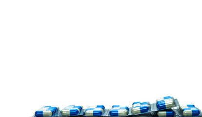 Wall Mural - Blue-white capsule pills in blister pack isolated on white background with copy space for text. Antibiotics drug resistance and antimicrobial drug use with reasonable concept. Global healthcare.