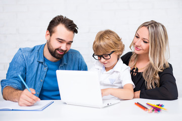 Sticker - parents helping to happy cute little school boy doing homework and using laptop