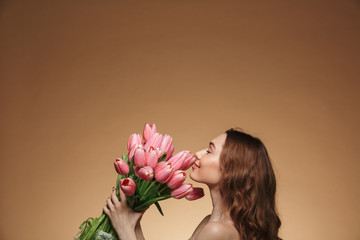 Canvas Print - Pretty young woman standing isolated holding tulips