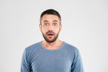 Wall Mural - Shocked young man standing isolated