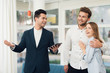 © Vadym Huzhva - Young couple in a meeting with a realtor. Guy and girl make a contract with realtor buying property.