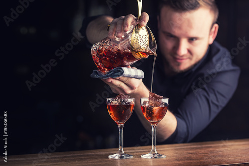 Fotomural Bartender pouring cocktail alcoholic drink Manhattan.