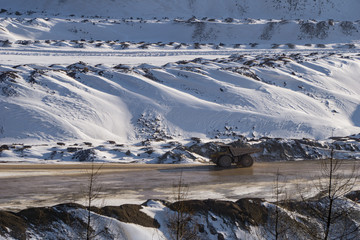 Wall Mural - Large truck transporting ore across an open pit mine in winter