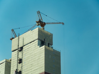 A condominium under construction with blue sky background.