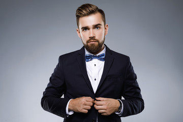 Wall Mural - Stylish handsome man wearing a classic suit with bow-tie